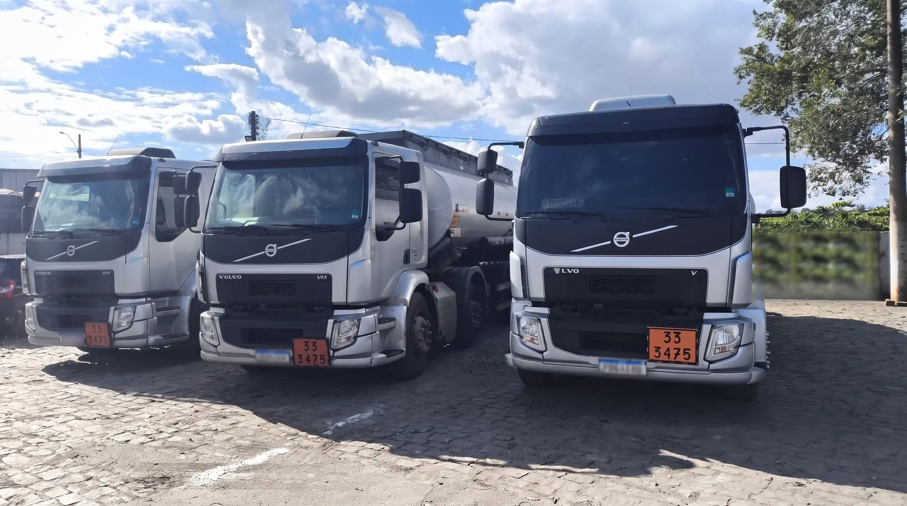 Três caminhões-tanque da Vertuani Transportes alinhados no pátio da empresa